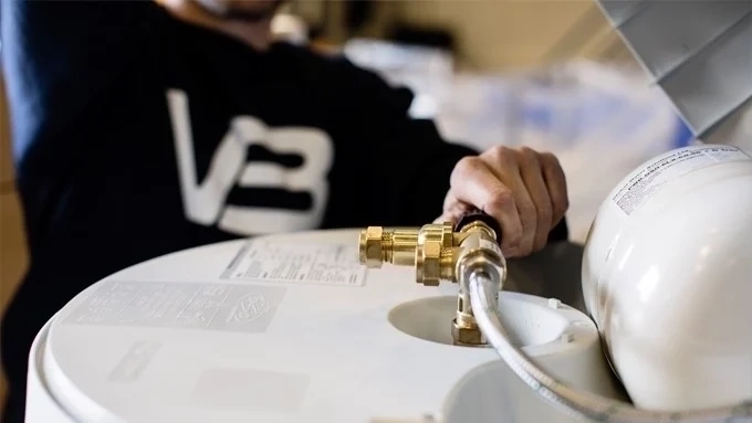 Rørlegger fra Trysil Rørleggerbedrift monterer ny varmtvannsbereder.